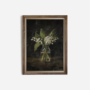 May include: A framed painting of a bouquet of white lilies in a clear glass vase. The lilies are arranged in a simple, elegant way, and the painting is done in a realistic style. The background is a dark, muted color, which helps to highlight the lilies.