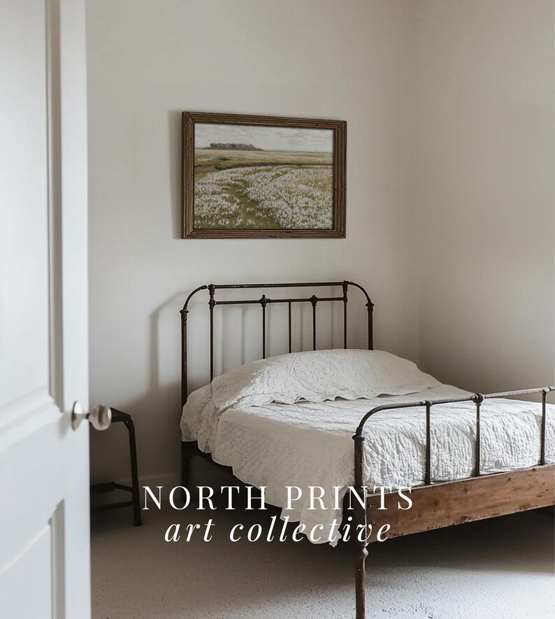 May include: A white bed with a black metal frame and a wooden headboard. The bed is in a room with white walls and a framed landscape painting above the headboard. The text "NORTH PRINTS art collective" is visible in the bottom of the image.