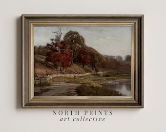 May include: A framed landscape painting depicting a river flowing through a woodland with trees in various shades of green and red. The painting is set in a rustic wooden frame with a gold trim.