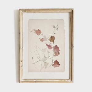 May include: A framed watercolor painting of a delicate branch with brown and pink leaves and small black berries. The painting is on a light beige background and is framed in a light wood frame.
