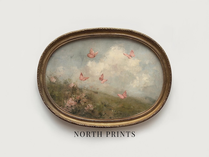 May include: An oval-shaped framed painting featuring a pastoral scene with pink butterflies fluttering in a cloudy sky. The artwork has a vintage aesthetic, with a gold-colored ornate frame. The text "NORTH PRINTS" is printed at the bottom of the frame.
