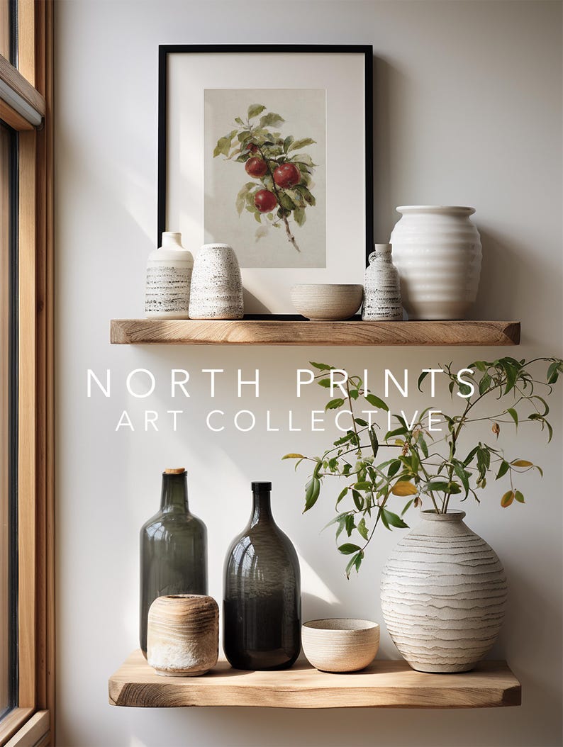 Peut inclure: Pr&eacute;sentation d'objets d&eacute;coratifs sur des &eacute;tag&egrave;res en bois. Une impression encadr&eacute;e de pommes rouges est suspendue au-dessus de divers vases en c&eacute;ramique, bols et bouteilles en verre. Le texte "NORTH PRINTS ART COLLECTIVE" est visible.