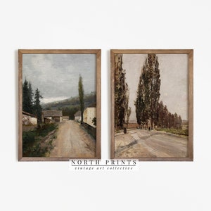 May include: Two framed vintage landscape paintings. The painting on the left shows a dirt road leading through a village with houses and trees. The painting on the right shows a dirt road lined with tall trees.