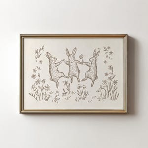 May include: A black and white line drawing of three rabbits dancing in a field of flowers. The rabbits are holding hands and jumping in the air. The flowers are simple and stylized.