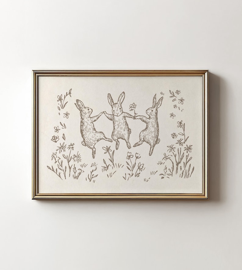 May include: A black and white line drawing of three rabbits dancing in a field of flowers. The rabbits are holding hands and jumping in the air. The flowers are simple and stylized.