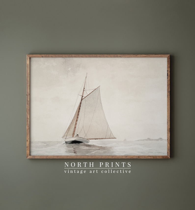 May include: A vintage watercolor painting of a sailboat with white sails on a calm sea. The painting is framed in a natural wood frame. The text "NORTH PRINTS vintage art collective" is printed below the image.