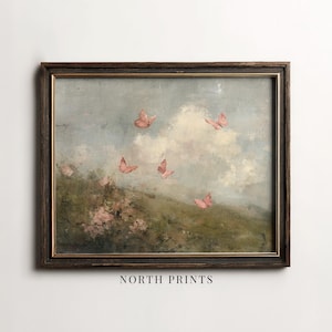 May include: Framed vintage-style artwork featuring a pastoral scene with pink butterflies fluttering against a cloudy sky. The painting has a dark brown wooden frame and the text "NORTH PRINTS" at the bottom.