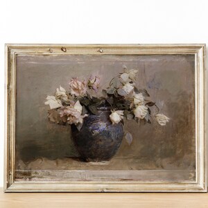 May include: A framed painting of a still life featuring a bouquet of white roses in a blue ceramic vase. The roses are arranged in a loose, natural style, and the vase is set on a table with a textured surface. The painting is done in a muted palette of browns, grays, and whites.