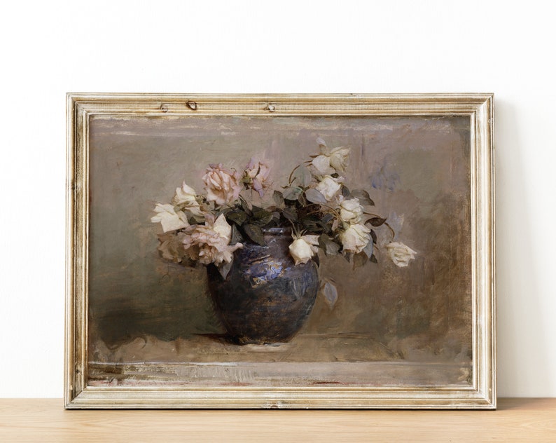 May include: A framed painting of a still life featuring a bouquet of white roses in a blue ceramic vase. The roses are arranged in a loose, natural style, and the vase is set on a table with a textured surface. The painting is done in a muted palette of browns, grays, and whites.