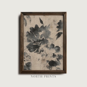 May include: A framed floral print featuring a large, abstract black and gray flower design on a beige linen background. The dark brown frame surrounds the artwork, with the text "NORTH PRINTS" at the bottom.