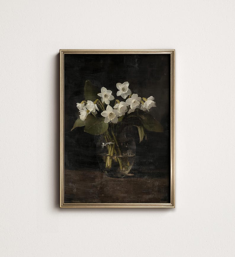May include: A framed painting of a bouquet of white flowers in a clear glass vase. The flowers are arranged in a simple, elegant way, and the background is a dark, moody color.