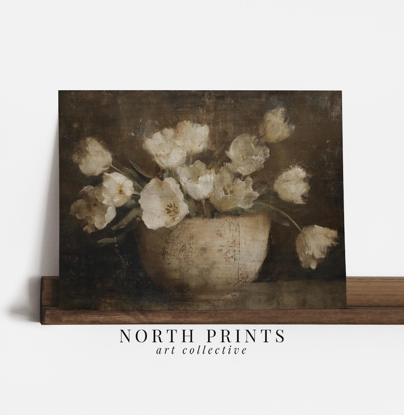 May include: A vintage-style print featuring a still life of white tulips in a cream-colored vase. The artwork has a dark, moody background and the text "NORTH PRINTS art collective" at the bottom.