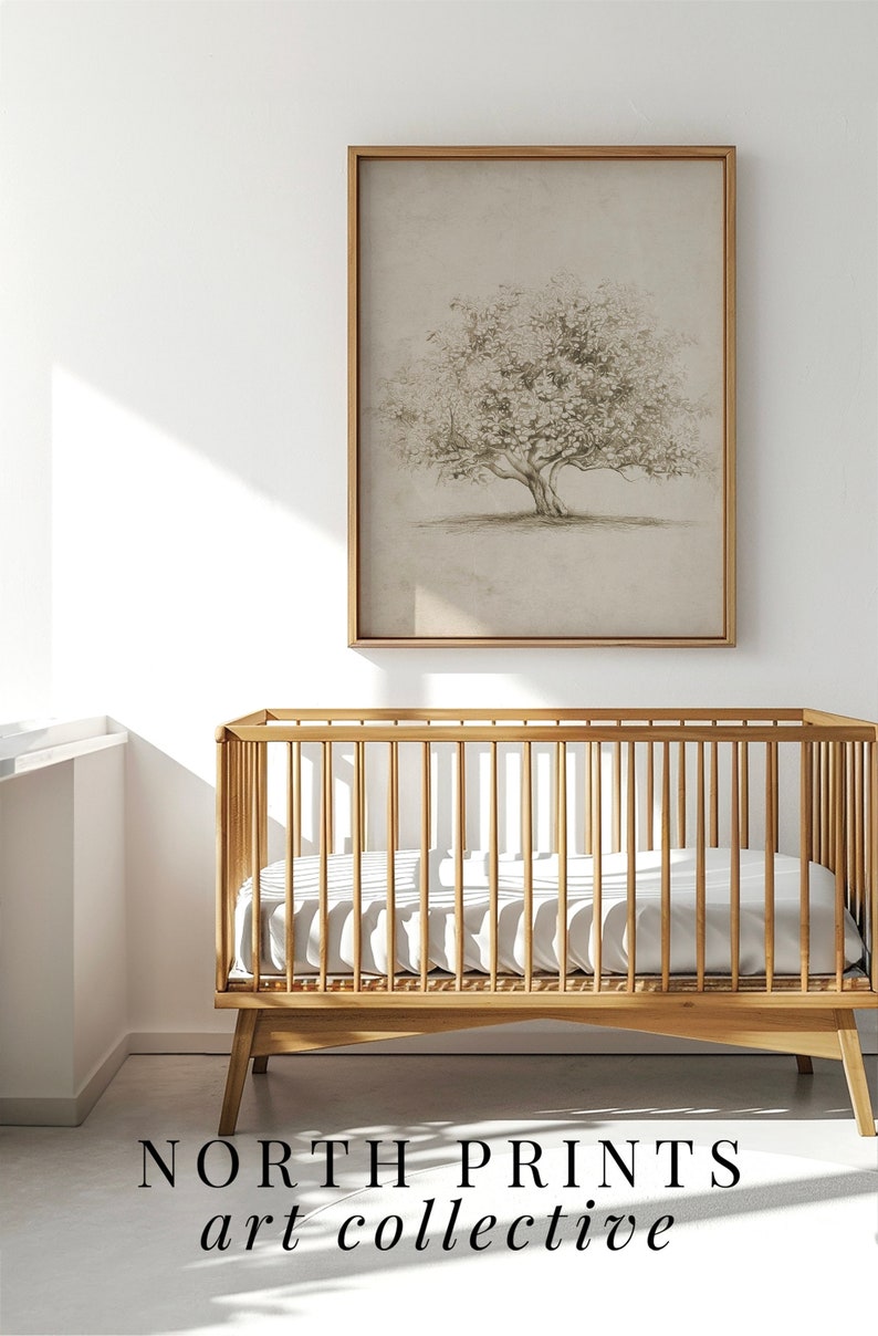 Op de afbeelding: Een houten wieg met een wit matras en een ingelijst tekening van een boom erboven. De tekst "NORTH PRINTS art collective" is onder de wieg gedrukt.