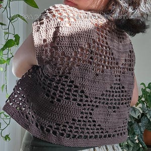 May include: A brown crochet top with a lacy pattern. The top has short sleeves and a scoop neck.