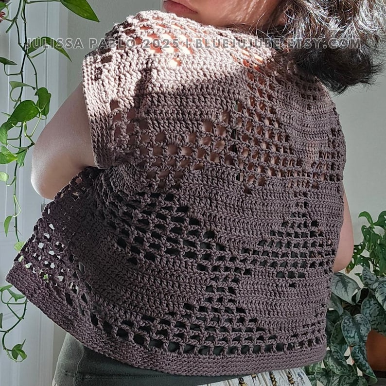 May include: A brown crochet top with a lacy pattern. The top has short sleeves and a scoop neck.