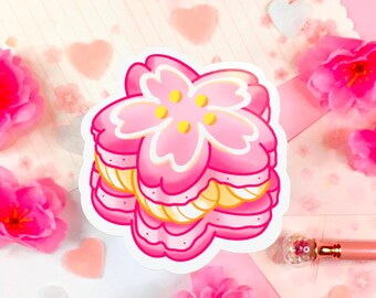 May include: A pink and yellow cherry blossom cookie sticker. The cookie is layered and has a white outline.