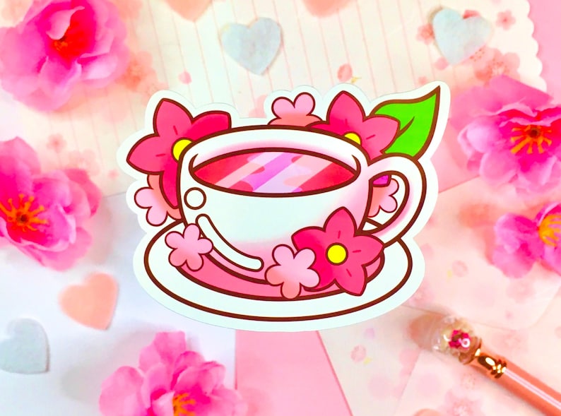 May include: A pink teacup and saucer with a pink floral design. The teacup is filled with pink tea and has a white rim. The saucer has a white rim and a pink floral design.