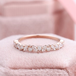 Op de afbeelding: Een delicate band van roségoud met een rij glinsterende marquise-vormige diamanten.