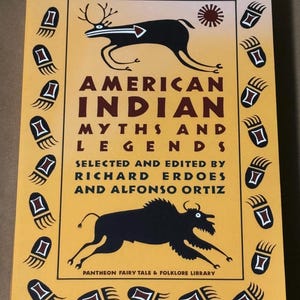 May include: A hardback book titled "American Indian Myths and Legends" with a yellow cover. The cover features black illustrations of a deer-like animal and a bison, with paw prints. The title is in large, maroon letters.