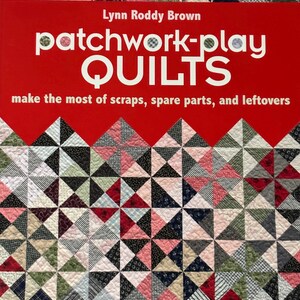 以下が含まれることがあります： リン・ロディ・ブラウン著『Patchwork-Play Quilts』というタイトルの本。赤い表紙に白い文字が書かれ、背景にはピンク、黒、白、緑の色合いの小さな三角形の布地が組み合わされたパターンがあり、隅に小さなロゴが配置されています。