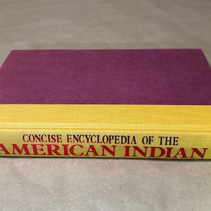 May include: A hardcover book titled "Concise Encyclopedia of the American Indian." The book has a purple cover and a yellow spine with red lettering. The book is a reference guide.
