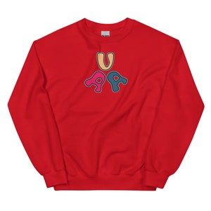 May include: Red sweatshirt with a graphic of the letters "U" and "PA" in a colorful, rounded font.