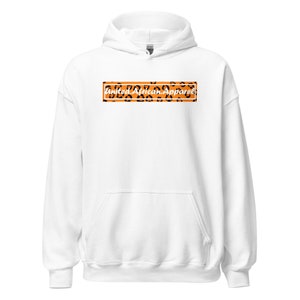 May include: White hooded sweatshirt with a black rectangle containing the text "United African Apparel" in white script on an orange background with a leopard print pattern.