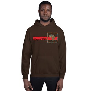 May include: A brown hoodie with a red and black stripe across the chest. The stripe has the text "Lagos Vibe" in black. A square with a colorful patterned design of an African continent is above the stripe.