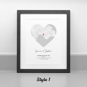 May include: A framed print featuring a heart-shaped map with a red heart icon marking a specific location. Below the map, the text reads: Lauren & Sophia, WHERE WE FIRST MET, TORQUAY, 50 27' 44.146" N, 3 31' 38.925" W, 12TH JANUARY 2024.