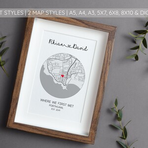 May include: A framed print with a gray and white map of Porthcawl, Wales. The map is centered around a red heart marking a location. The names "Rhian & David" and the text "Where we first met, Porthcawl, Est 201" are printed below the map.