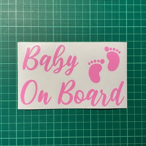 May include: Pink vinyl sticker with the text "Baby On Board" and two pink baby footprints.