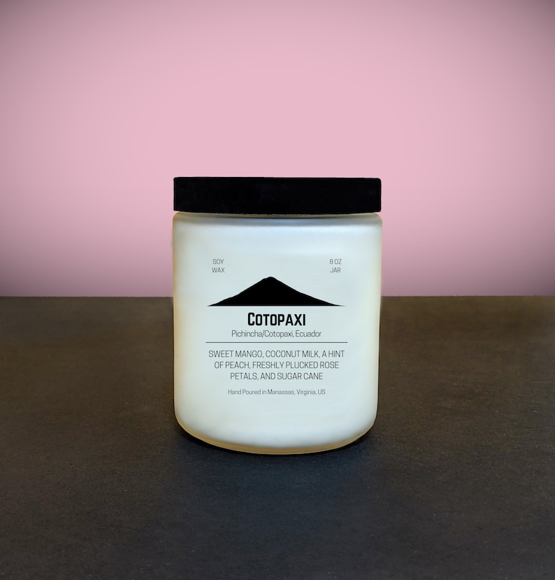 Może przedstawiać: Biała świeca w słoiku o wadze 227g z czarną pokrywką. Etykieta zawiera napis "COTOPAXI" nad grafiką g&oacute;rską. Etykieta wymienia r&oacute;wnież zapach jako słodkie mango, mleko kokosowe, brzoskwinia, płatki r&oacute;ż i trzcina cukrowa. Ręcznie nalewana w Wirginii, USA.