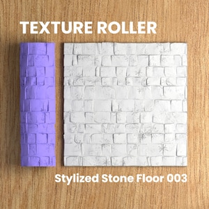 May include: A purple textured roller for creating a stylized stone floor pattern. The roller is next to a sample of the pattern, which is a white stone floor with a stylized brick pattern.