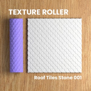 Può includere: Rullo di texture viola con un motivo di semicerchi sovrapposti. Il rullo è accanto a un campione del motivo, che è bianco con una superficie testurizzata. Il testo "Roof Tiles Stone 001" è sotto il campione.