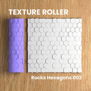 May include: A purple texture roller with a hexagonal pattern. The roller is next to a white sheet with the same hexagonal pattern. The text "Rocks Hexagons 002" is below the image.