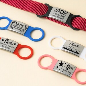 K&ouml;nnte beinhalten: F&uuml;nf verschiedene Hunde-ID-Tags in verschiedenen Farben und Designs. Die Tags zeigen die Namen "Katie", "Phoebe", "Charlie", "Max" und "Jade" sowie Telefonnummern und zus&auml;tzliche Informationen.