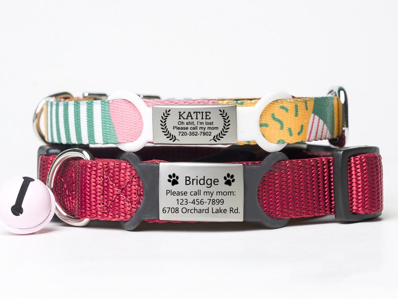 May include: Two dog collars with personalized metal tags. The top collar is green, pink, and yellow with a white buckle. The tag reads "KATIE Oh shit, I'm lost Please call my mom 720-352-7902". The bottom collar is red with a black buckle. The tag reads "Bridge Please call my mom: 123-456-7899 6708 Orchard Lake Rd."