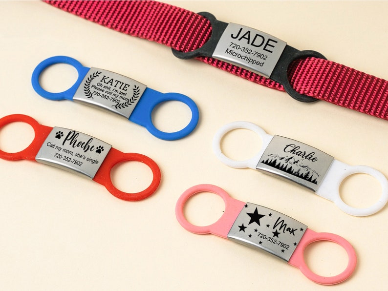 May include: Five different dog ID tags with various colors and designs. The tags feature engraved names, phone numbers, and messages. The tags are attached to different colored collars.