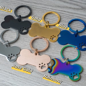 Puede incluir: Seis llaveros con forma de hueso de perro en diferentes colores: negro, dorado, azul, plateado, oro rosa y arco&iacute;ris. Cada llavero tiene un recorte en forma de huella de pata y un anillo de metal.