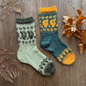 May include: A pair of knitted socks with a squirrel pattern. One sock is green and yellow, the other is green and brown.