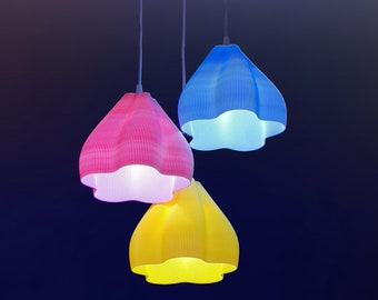 May include: Three hanging light fixtures with colorful, ruffled lampshades. The shades are pink, blue, and yellow.