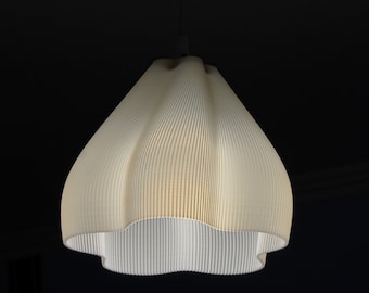 May include: A white, pleated, hanging lampshade with a rounded, scalloped bottom.