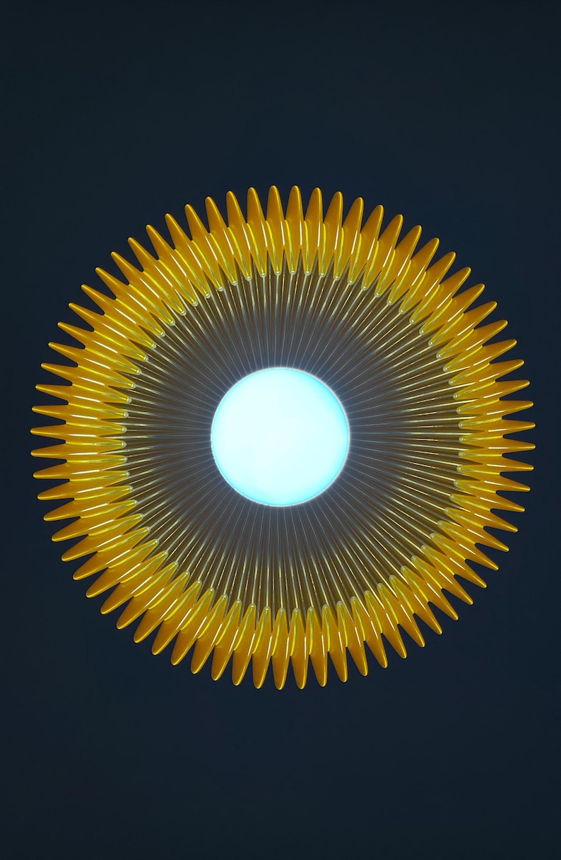 Peut inclure: Un luminaire circulaire dot&eacute; d'un centre blanc brillant et lumineux, entour&eacute; d'un &eacute;ventail radial de nombreux rayons fins jaune dor&eacute; qui s'&eacute;tendent vers l'ext&eacute;rieur pour former un motif en &eacute;toile sur un fond sombre et uni.