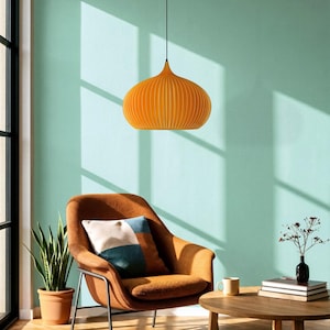 Peut inclure: Une suspension orange vif avec une forme arrondie et nervur&eacute;e, suspendue par un fin cordon noir. Le luminaire pr&eacute;sente une s&eacute;rie de lattes verticales cr&eacute;ant une silhouette sym&eacute;trique distincte, diffusant la lumi&egrave;re vers le bas de mani&egrave;re uniforme.