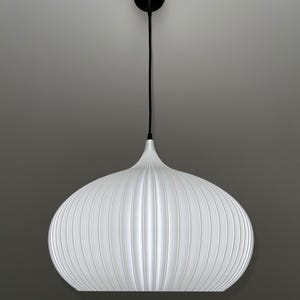 A white pendant light with a rounded, ribbed, and bulbous shade. The fixture is suspended by a thin black cord attached to a small, circular black ceiling canopy. The shade features vertical ridges that create a textured appearance.