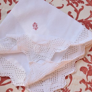 May include: White linen handkerchief with a delicate crocheted lace border and a red embroidered monogram "TP".