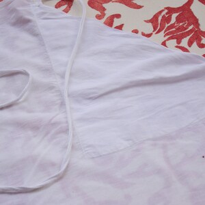 May include: White cotton fabric with a white drawstring and red embroidered floral design.