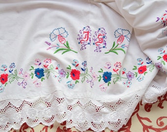 May include: White linen tablecloth with embroidered floral designs and the initials "JS" in the center. The tablecloth has a lace trim.