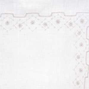 May include: White linen handkerchief with a delicate embroidered border featuring a repeating pattern of small flowers and circles. The initials "VM" are embroidered in the lower left corner.
