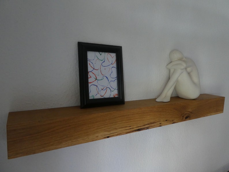 Puede incluir: Una estanter&iacute;a de madera con una escultura de cer&aacute;mica blanca y un cuadro enmarcado con arte abstracto de colores. La estanter&iacute;a est&aacute; hecha de madera natural con un acabado r&uacute;stico.